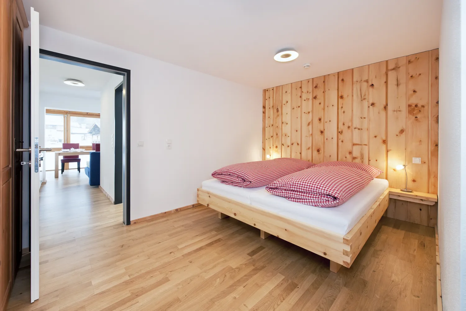 Schlafzimmer mit Doppelbett aus Zirbenholz im Junior Suite-Apartment